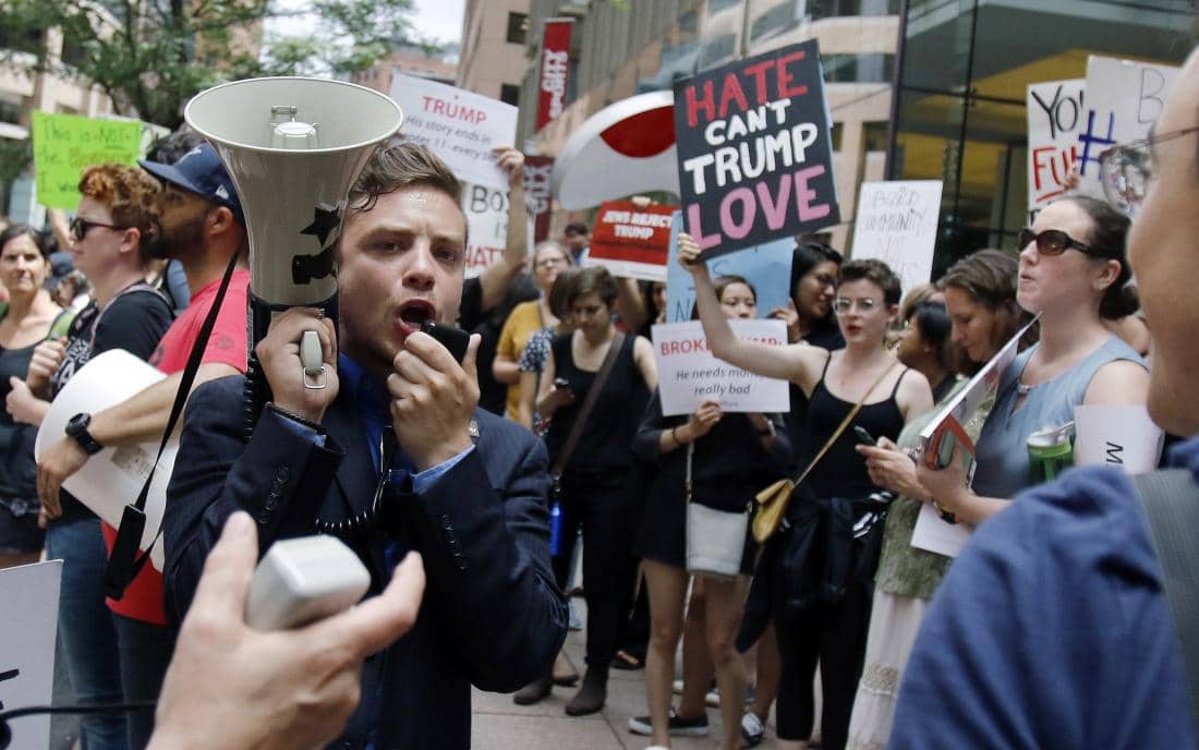 Protestors chant outside a downtown hotel in Boston, Wednesday, June 29, 2016, where Republican presidential candidate Donald Trump was holding a lunchtime fundraiser. Trump was scheduled to hold a rally later in the afternoon in Bangor, Maine. (AP Photo/Bill Sikes)